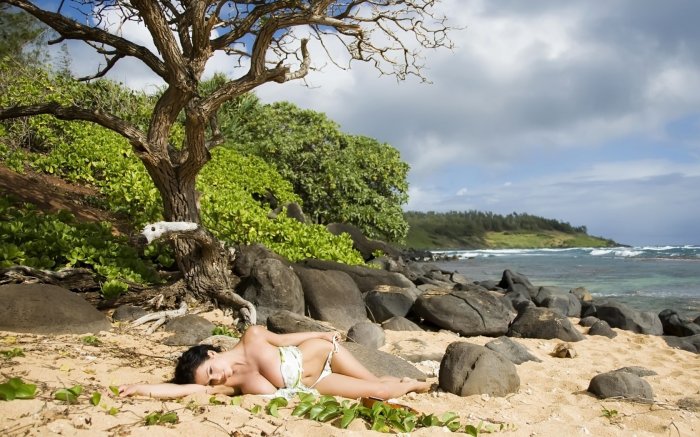The girl is relaxing on a stony beach