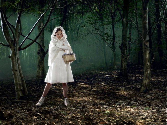 The girl is dressed in white and walks in a mysterious forest