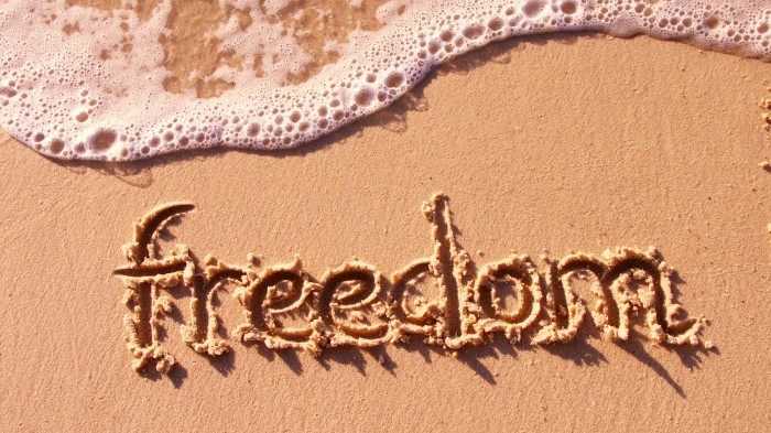 The inscription “Freedom” on the sand